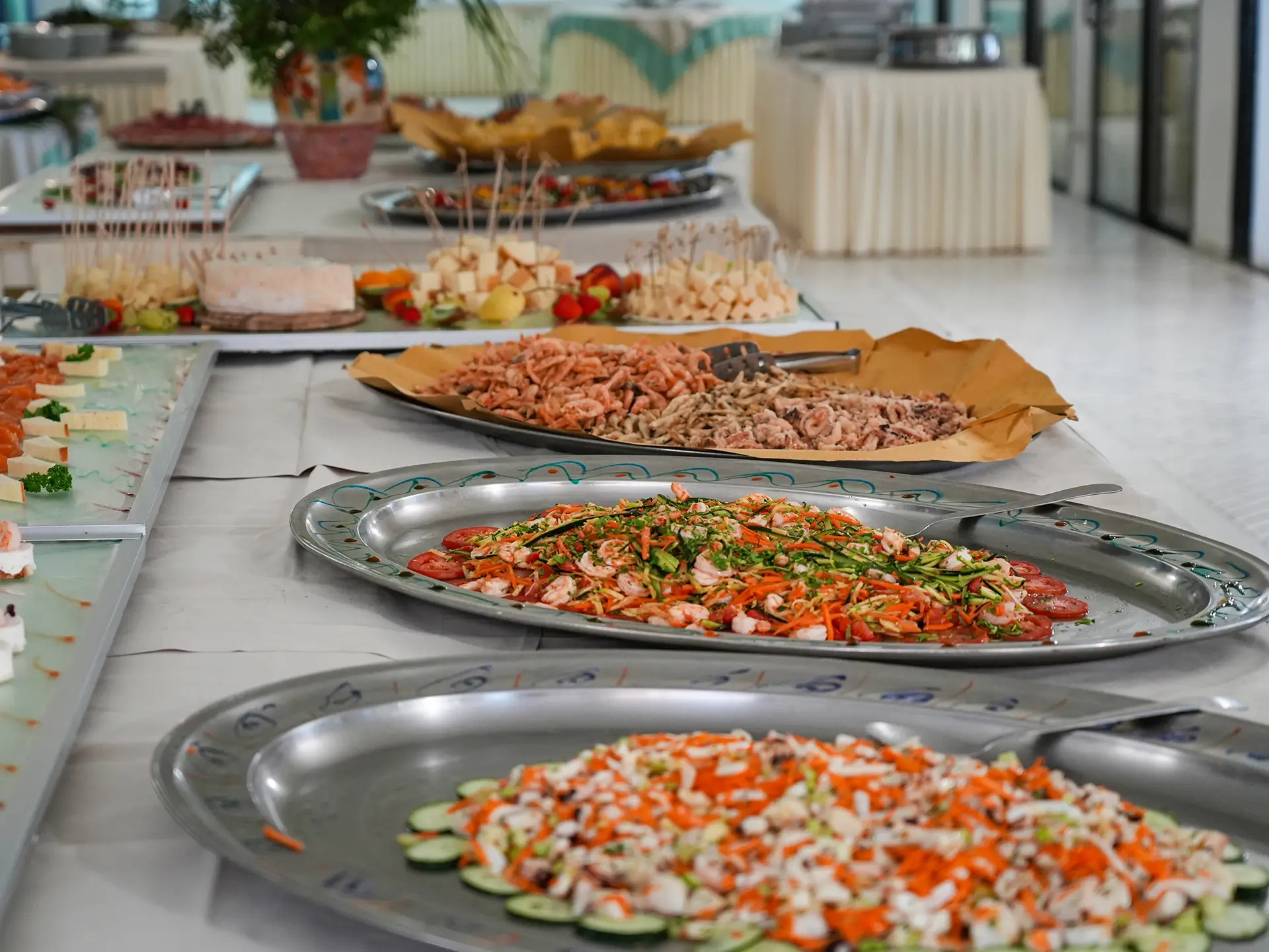 Buffet dell'hotel con vassoi di insalate, pesce e antipasti freschi in bella mostra