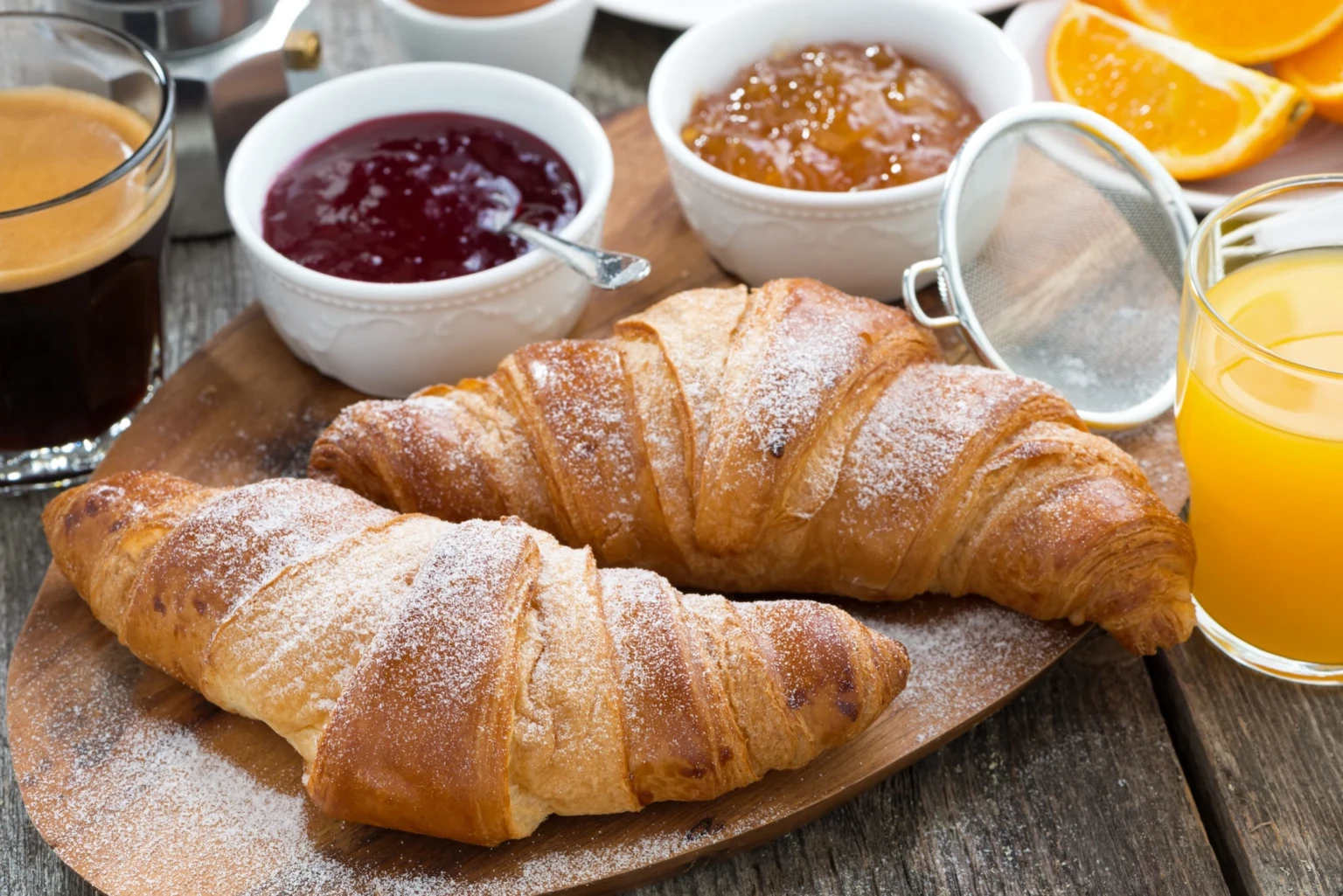 Frühstückstisch mit frischen Croissants, Marmeladen, Kaffee und Orangensaft im Hotel auf Elba