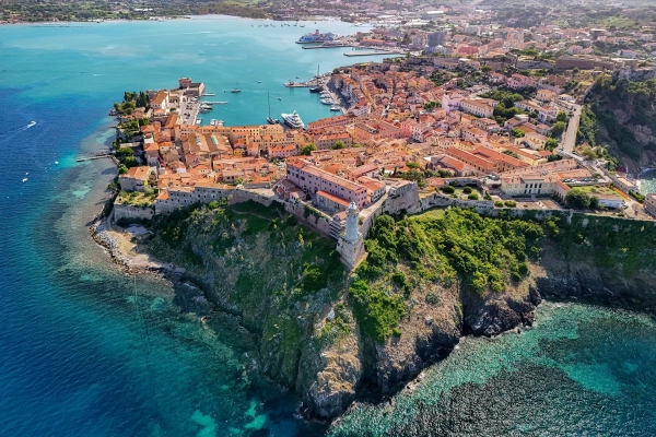 Vista aerea del borgo fortificato di Marciana Marina sulla scogliera, con mare turchese all'Isola d'Elba
